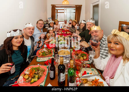 Un multi etnico famiglia sedersi ad un tradizionale pranzo di Natale, Sussex, Regno Unito Foto Stock