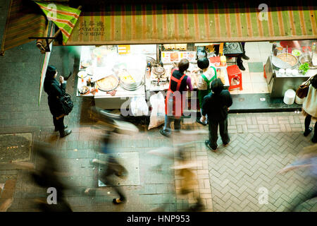 I clienti scelgono il cibo dalla strada notte stallo in Hong Kong Foto Stock