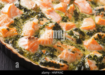 Appena sfornato sformatino salato con salmone e spinaci macro sul tavolo orizzontale. Foto Stock