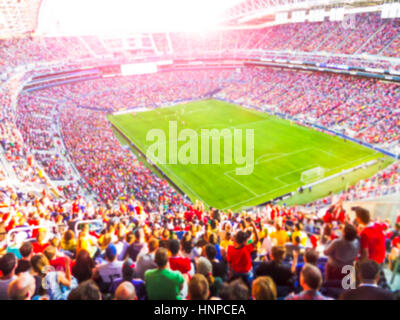 Football - soccer fans allietare il loro team e celebrare obiettivo in stadio pieno con aria aperta con un luminoso fascio di illuminazione -sfocata. Foto Stock