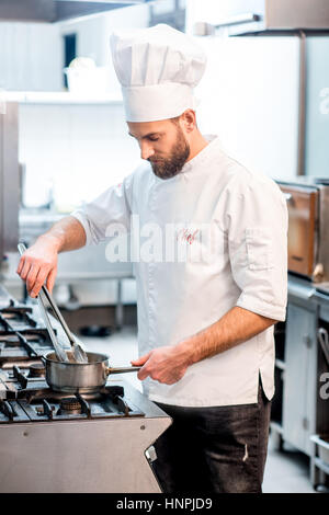 Ritratto di chef di cucina in uniforme con coltelli al ristorante cucina Foto Stock