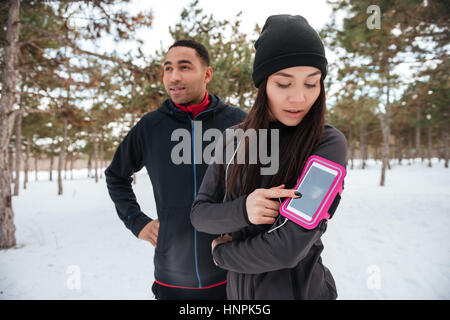 Giovani multirazziale sport giovane ottenere pronto per l'esecuzione di maratona in foresta invernale Foto Stock