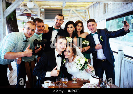 Spose il giorno del nostro matrimonio con gli amici in un bar Foto Stock