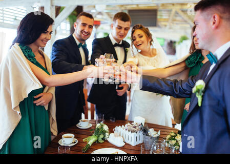 Spose il giorno del nostro matrimonio con gli amici in un bar Foto Stock