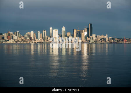 Come il sole tramonta edifici della skyline di Seattle sono riflesse nella Baia di Elliott. Foto Stock