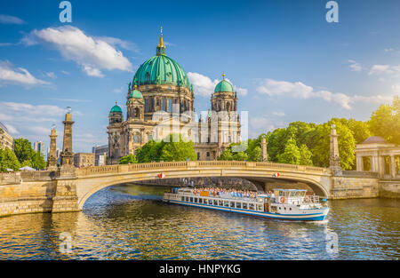 Bellissima vista della storica cattedrale di Berlino (Berliner Dom) alla famosa Isola dei Musei con nave passando Friedrichsbrucke ponte sul fiume Spree al tramonto Foto Stock