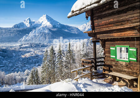Bellissima vista della Scenic bianco inverno paese delle meraviglie del paesaggio di montagna delle Alpi con tradizionale baita in legno in una fredda giornata di sole Foto Stock