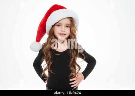 Ricci graziosa bambina santa claus hat permanente e la posa su sfondo bianco Foto Stock