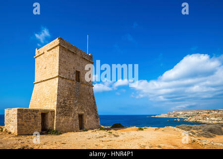 Malta - Ghajn Tuffieha torre di avvistamento al Golden Bay su una soleggiata giornata estiva con cielo blu chiaro Foto Stock