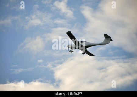 Piccolo aereo nell'aria. Il cielo blu con nuvole bianche. Foto Stock