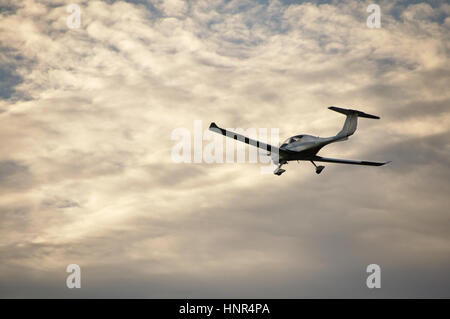 Piccolo aereo nell'aria. Il cielo blu con nuvole bianche. Foto Stock