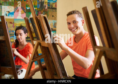 Scuola di arte, College of Arts, istruzione per il gruppo di studenti. Portraif di felice ispanico giovane uomo sorridente, guardando la fotocamera. Foto Stock