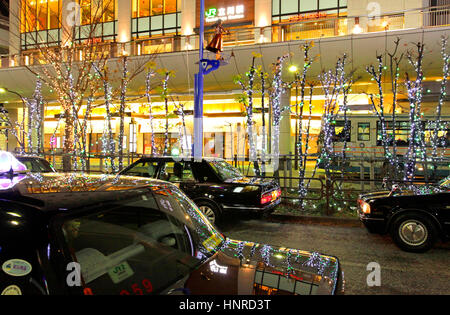 Notte di Natale Scape fila di taxi in attesa di clienti di fronte Tachikawa Stazione ferroviaria Tokyo Giappone Foto Stock