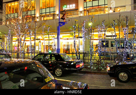 Notte di Natale Scape fila di taxi in attesa di clienti di fronte Tachikawa Stazione ferroviaria Tokyo Giappone Foto Stock