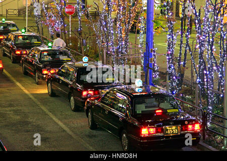 Notte di Natale Scape fila di taxi in attesa di clienti di fronte Tachikawa Stazione ferroviaria Tokyo Giappone Foto Stock