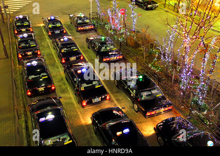 Notte di Natale Scape fila di taxi in attesa di clienti di fronte Tachikawa Stazione ferroviaria Tokyo Giappone Foto Stock