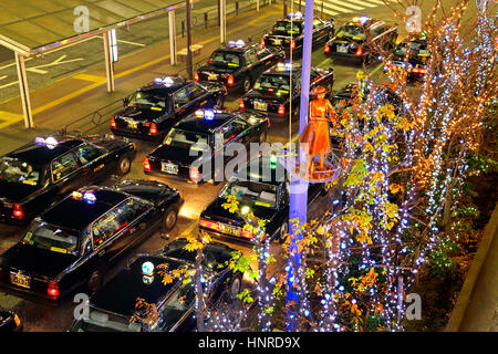 Notte di Natale Scape fila di taxi in attesa di clienti di fronte Tachikawa Stazione ferroviaria Tokyo Giappone Foto Stock