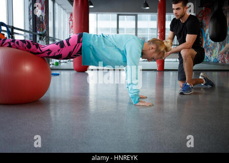 Giovane donna su fitball presso la palestra dell'abbigliamento sportivo Foto Stock