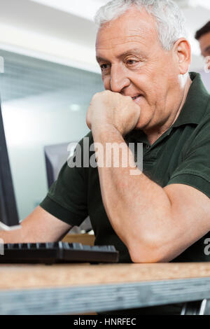 Senior uomo l uso dei computer in aula Foto Stock