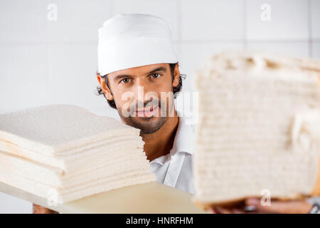 Fiducioso baker maschio con le fette di pane Foto Stock
