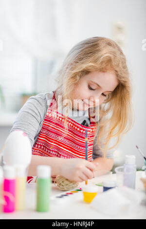 Bimba bionda uova di colorazione per vacanze di Pasqua a casa Foto Stock