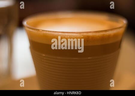 Caffè in tazza di vetro. Piatto bianco. Profondità di campo ridotta. Foto Stock