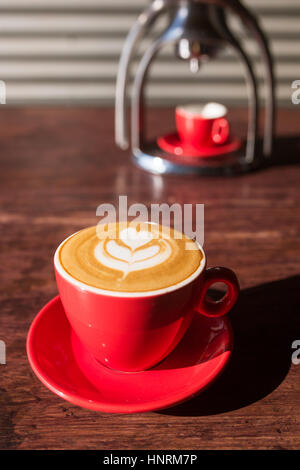 Manuale scuola vecchia macchina espresso macchina con una tazza sul tavolo di legno in bella luce del mattino Foto Stock