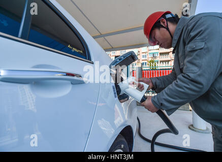 Wenzhou, cinese della Provincia di Zhejiang. Xvi Feb, 2017. Un membro del personale spese un auto elettrica in corrispondenza di una stazione di carica veloce in Wenzhou, est della Cina di Provincia dello Zhejiang, Feb 16, 2017. Una stazione di carica veloce con otto pile carica aperto qui il giovedì. Credito: Xu Yu/Xinhua/Alamy Live News Foto Stock