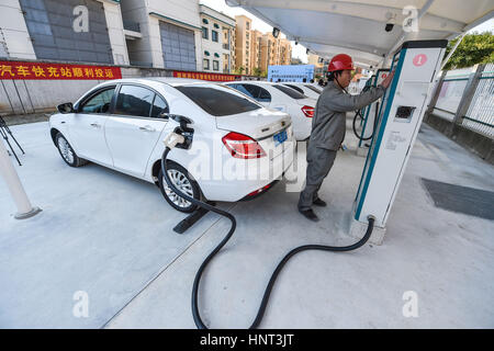 Wenzhou, cinese della Provincia di Zhejiang. Xvi Feb, 2017. Un membro del personale spese un auto elettrica in corrispondenza di una stazione di carica veloce in Wenzhou, est della Cina di Provincia dello Zhejiang, Feb 16, 2017. Una stazione di carica veloce con otto pile carica aperto qui il giovedì. Credito: Xu Yu/Xinhua/Alamy Live News Foto Stock