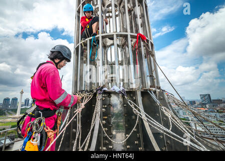 Jakarta, Indonesia. 17th Febbraio, 2017. I volontari controllano gli ancoraggi sotto il pinnacolo della torre alta 66,66 metri della Moschea Istiqlal a Jakarta, Indonesia. Decine di membri dei club appassionati di attività all'aperto, società di accesso alla corda e organizzazione di servizi di avventura all'aperto, si riuniscono volontariamente per ripulire la più grande moschea del sud-est asiatico per rafforzare l'unità nazionale, la solidarietà e la tolleranza. Foto Stock