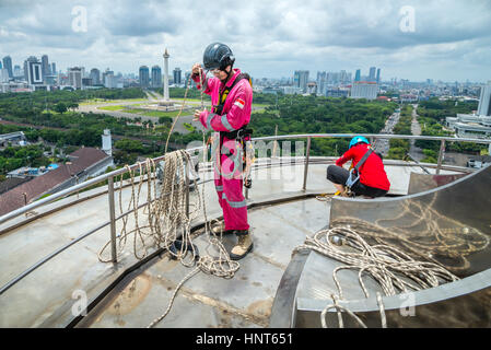 Jakarta, Indonesia. 17th Febbraio, 2017. Gli operai volontari arrotolano le corde alla piattaforma più alta della torre alta 66,66 metri di altezza della moschea Istiqlal a Jakarta, Indonesia. Decine di membri dei club appassionati di attività all'aperto, società di accesso alla corda e organizzazione di servizi di avventura all'aperto, si riuniscono volontariamente per ripulire la più grande moschea del sud-est asiatico per rafforzare l'unità nazionale, la solidarietà e la tolleranza. Foto Stock