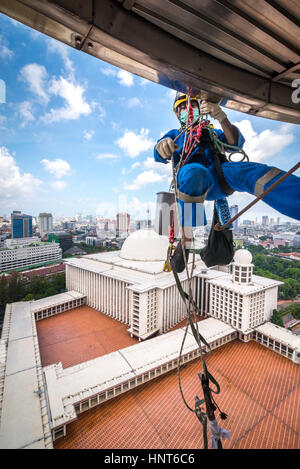 Jakarta, Indonesia. 17th Febbraio, 2017. Un lavoratore volontario scende le corde per iniziare a pulire le pareti esterne della torre alta 66,66 metri della Moschea Istiqlal a Jakarta, Indonesia. Decine di membri dei club appassionati di attività all'aperto, società di accesso alla corda e organizzazione di servizi di avventura all'aperto, si riuniscono volontariamente per ripulire la più grande moschea del sud-est asiatico per rafforzare l'unità nazionale, la solidarietà e la tolleranza. Foto Stock