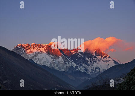 Ultima luce sul monte Everest sul Nuptse e Lhotse con poche nuvole visto da Tengboche Foto Stock