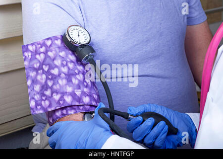 Mani guantate controllando la pressione del sangue sul sovrappeso paziente di sesso maschile. Valutazione di ipertensione. Vicino sul sfigmomanometro e stetoscopio. Foto Stock