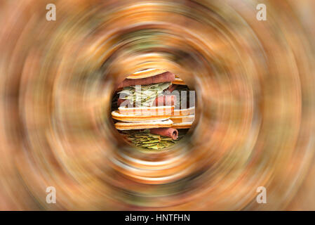 Fette di disidratare le arance, le foglie di alloro e bastoncini di cannella appendere ghirlande. Naturale profumato di fragranze di filatura di frutta sfocato intorno al centro Foto Stock