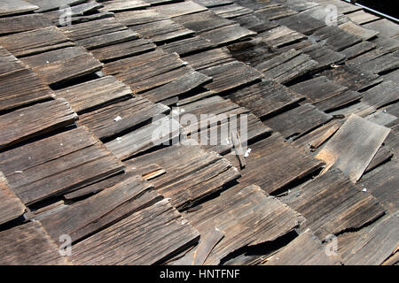 Agitare di legno ghiaia tetto più di trenta anni decadendo e cade a pezzi. Superato l'aspettativa di vita e deve essere sostituito. Foto Stock