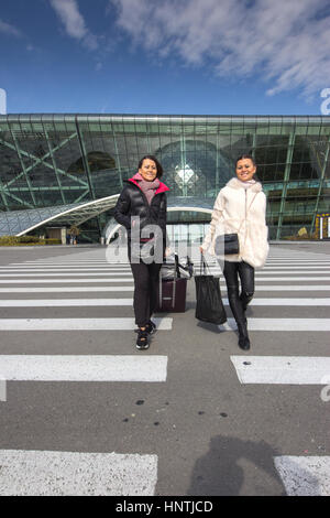 Bellissimi gemelli donne in viaggio - a piedi con i bagagli in aeroporto Parcheggio Auto Foto Stock