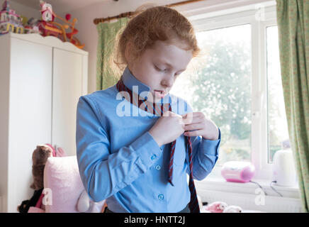 Una bambina ottenere pronto per junior school. Foto Stock