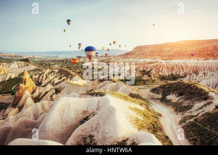 Mongolfiera Volare oltre il paesaggio di roccia a Cappadocia la Turchia. Foto Stock