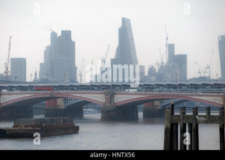 Torre 42, Cheesegrater, iconico grattacieli sulla City di Londra il quartiere finanziario e dello skyline di Blackfriars Bridge in un cupo, nebbiosa mattina Foto Stock