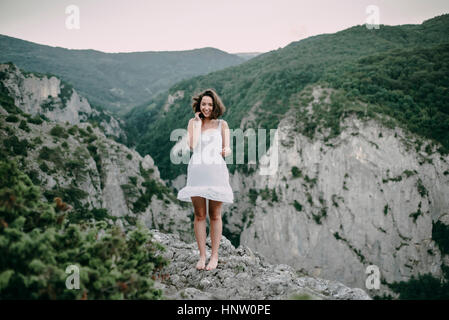 Sorridente donna caucasica permanente sulla montagna Foto Stock