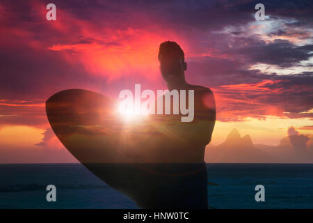 La doppia esposizione di sorridere razza mista uomo con la tavola da surf in spiaggia Foto Stock