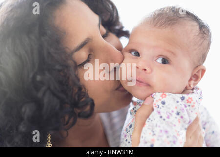 Madre ispanica kissing bimba sulla guancia Foto Stock