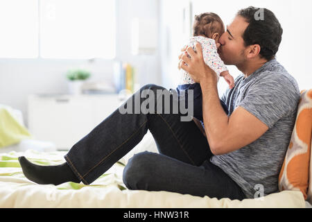 Padre ispanica kissing bimba sulla guancia Foto Stock