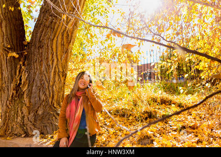 Donna asiatica parlando al cellulare in autunno Foto Stock