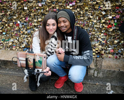 14/02/2017. Il giorno di San Valentino, una coppia giovane prendere un selfie davanti all amore si blocca al Pont Neuf a Parigi, Francia Foto Stock
