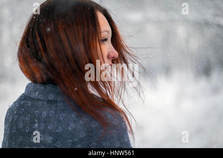 I capelli della donna caucasica soffiando nel vento in inverno Foto Stock