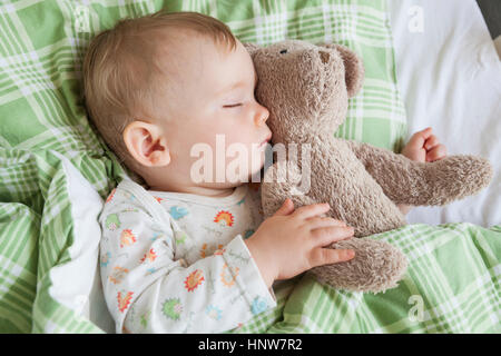 Vista aerea del bambino addormentato sul letto azienda orsacchiotto Foto Stock