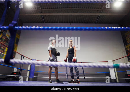 Giovane maschio e femmina boxer in piedi di pugilato ring Foto Stock