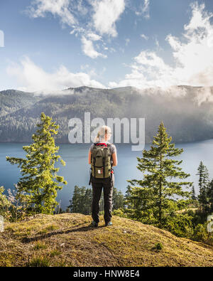 Escursionista femmina affacciato sul lago Comox, Coutenay, Isola di Vancouver, British Columbia, Canada Foto Stock